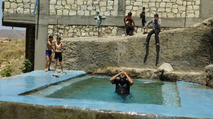 Gercüş’te çiftçiler, doğal kaynak suyuyla doldurdukları havuzda serinliyor
