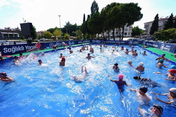 Manisa'da çocuklar hem serinliyor hem yüzmeyi öğreniyor
