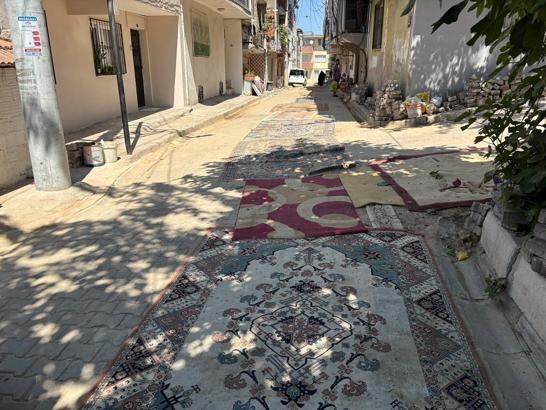 Mahalleli tozdan korunmak için onarılmayan yollara halı serdi