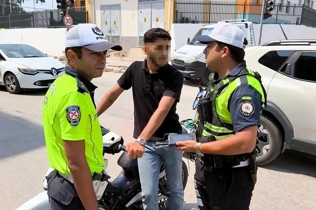Ehliyetsiz sürücü, motosikletini araçların arasına park edip uygulamadan kaçmak isterken yakalandı