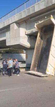 Kamyonun açılan damperi, köprüye takıldı