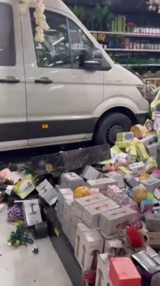 Mağazaya giren minibüsün altında kalmaktan son anda kurtuldular