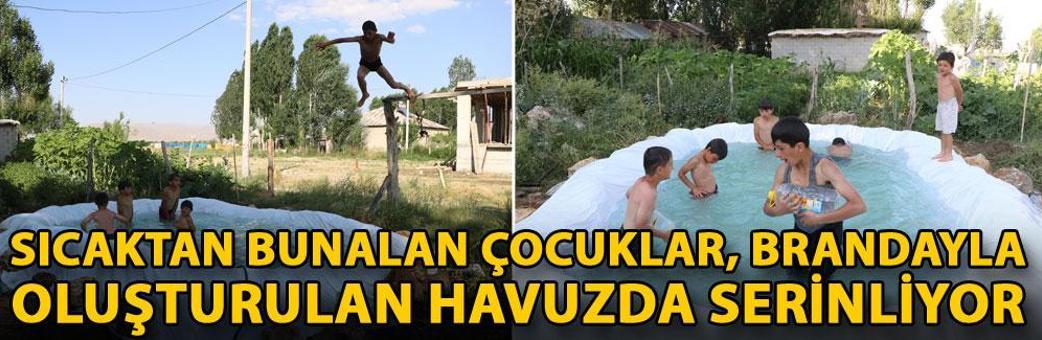 Sıcaktan bunalan çocuklar, brandayla oluşturulan havuzda serinliyor