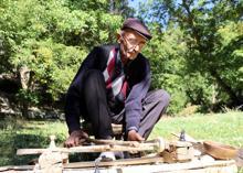 Eski usul tezgahta ceviz ağacından satranç taşı yapıyor