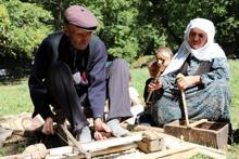 Eski usul tezgahta ceviz ağacından satranç taşı yapıyor