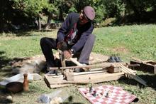 Eski usul tezgahta ceviz ağacından satranç taşı yapıyor