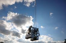 Helikoptere bağlı sepetle elektrik iletim hatlarına bakım yaparken ölüme meydan okuyorlar