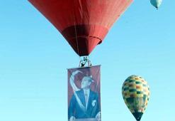Hot air balloons take off with Ataturk poster and flag in Cappadocia