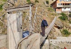 İki dağ arasındaki evine kapılı asma köprüyle ulaşıyor