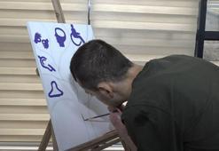 Kelebek hastalığından iki elini kaybeden Ömer, kollarıyla resim yapıyor