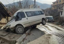 Buzlu yolda kayan minibüs askıda kaldı