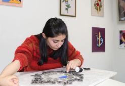 Sol el ve ayağı ile çivi çakıp, filografi tablolar yapıyor