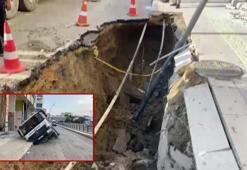 Temizlik aracı, ağır hasarlı binanın önünden geçerken çöken yola devrildi