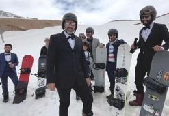 Takım elbise, kravat ve papyonla snowboard