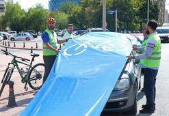 Bisiklet yolunu kapatan araçların üzerine branda çekip tepki gösterdiler