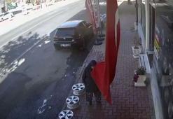 Bastonla yürüyen kadının iş yeri önündeki bayrağı öpmesi kamerada