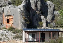 Binlerce yıllık kaya mezarın önüne ev yaptı