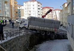 Buzda kayan kamyon, derenin duvarında asılı kaldı