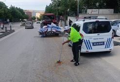Polis, traktörden düşerek yola saçılan kuzu yemlerini topladı
