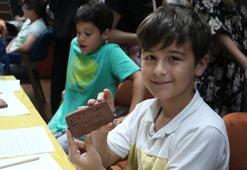 Çocuklar kile çivi yazısı ile isimlerini yazdı