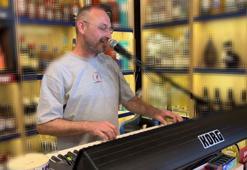 Marketine gelen müşterileri org çalıp şarkı söyleyerek karşılıyor