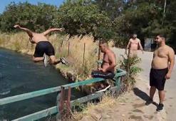 Tehlikeye aldırmadan sulama kanalında serinlediler