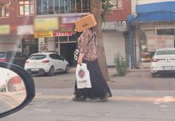 Başına karton kutu geçirerek sıcaktan korunmaya çalıştı