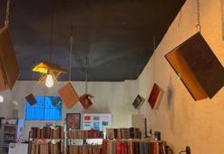 Kitapları, dijital çağa yenilmesine dikkat çekmek için kafenin tavanına astı