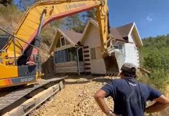 Yıkım kararı verilen konteyner evini iş makinesiyle karadan rayla yürütüp taşıdı
