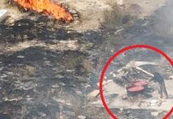 Alevlere rağmen salça karıştırmaya devam etti