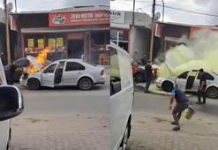 Otomobilde çıkan yangını esnaf söndürdü