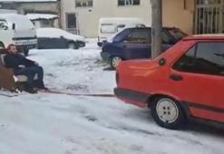 Otomobile bağladığı koltukla kayak yaptı
