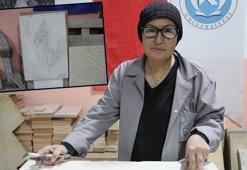 Hat sanatı hocası, tarihi Rum Yetimhanesi'nin bahçesinde kurulan atölyede taşa şekil veriyor