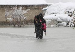 Evinin önünde biriken su nedeniyle çocuklarını sırtında taşıyor