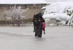 Evinin önünde biriken su nedeniyle çocuklarını sırtında taşıyor