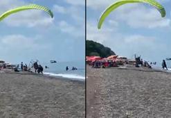 Sahilde motorlu yamaç paraşütüyle havalanırken tatilcilerin arasına daldı