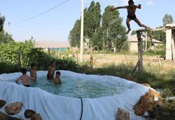 Sıcaktan bunalan çocuklar, brandayla oluşturulan havuzda serinliyor