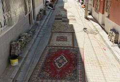 Mahalleli tozdan korunmak için onarılmayan yollara halı serdi