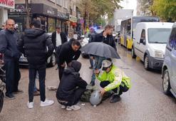 Kadın polis, yaralı ıslanmasın diye başında şemsiyeyle bekledi