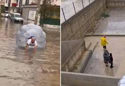Sağanakta suyla dolan caddede içine girdiği büyük şeffaf balonla ilerledi