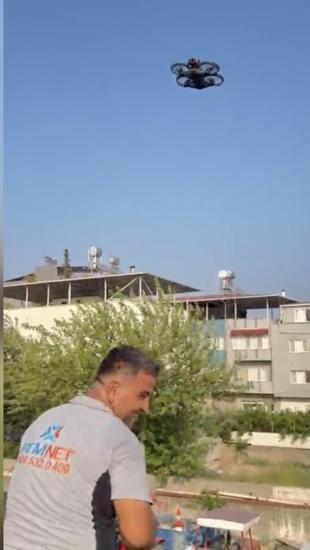 Patrondan çatıda güneş altında çalışan işçilere dronla soğuk içecek servisi