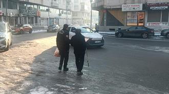 Kardan kayganlaşan yolda yürüyemeyen görme engelliyi markete polis götürdü
