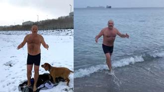 Avcılar'da karlı havaya aldırış etmeden köpeğiyle beraber denizde yüzdü