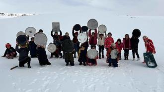 Evlerden getirdikleri tepsilerle köy merasında kaydılar
