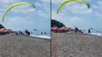 Sahilde motorlu yamaç paraşütüyle havalanırken tatilcilerin arasına daldı