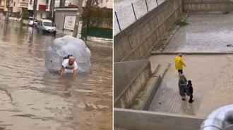 Sağanakta suyla dolan caddede içine girdiği büyük şeffaf balonla ilerledi