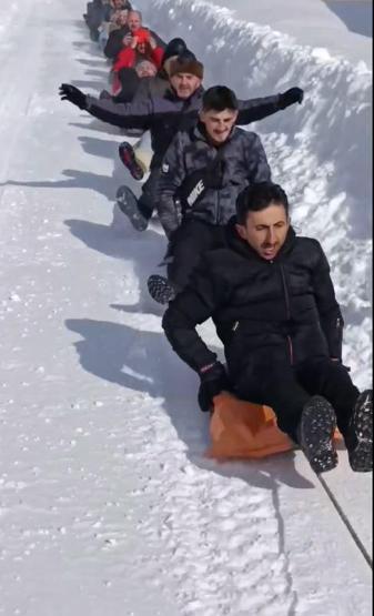 Kamyonete bağlanan ipe tutturulan şambrellerin üzerine oturup kaydılar