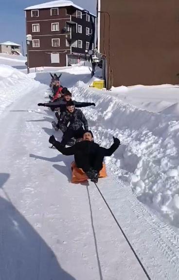 Kamyonete bağlanan ipe tutturulan şambrellerin üzerine oturup kaydılar
