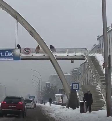 Üst geçitte kar topu atan çocukları yumruklayıp, yerde tekmeledi