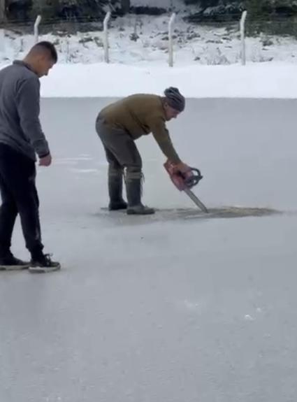 Donan göletin yüzeyindeki buzu motorlu testere ile kesti